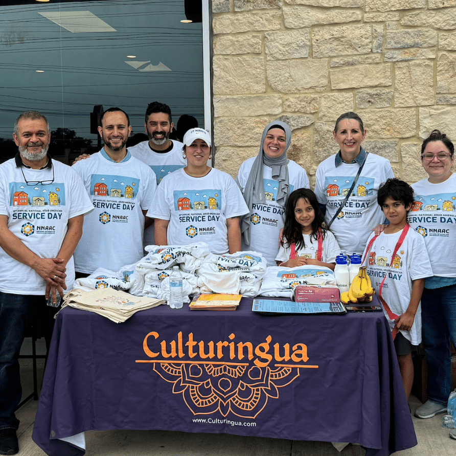 People representing Culturingua, around a table with a table cloth that has their logo.